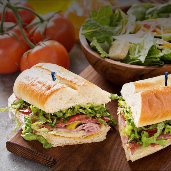 A Hand-made delicious sandwich with a side salad